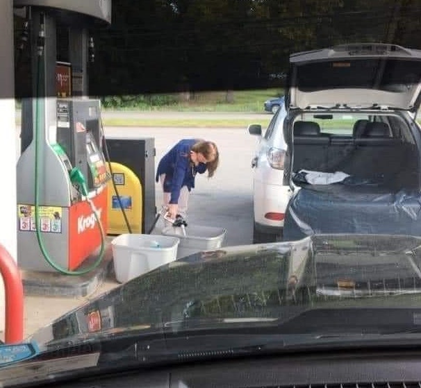 woman fills up plastic storage container with gas