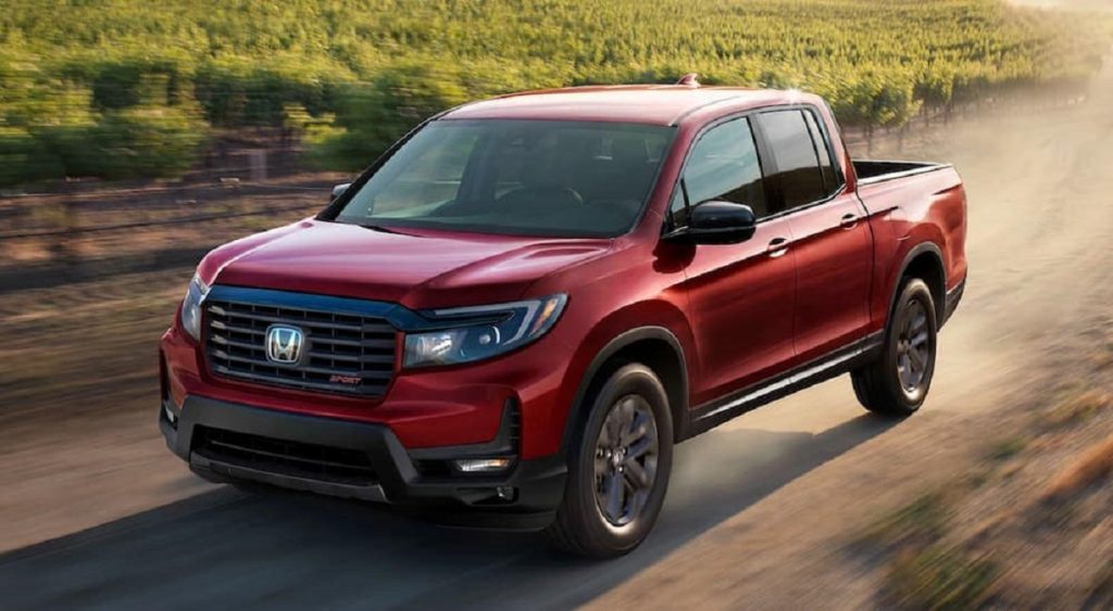 a red 2021 Honda Ridgeline driving on a country road