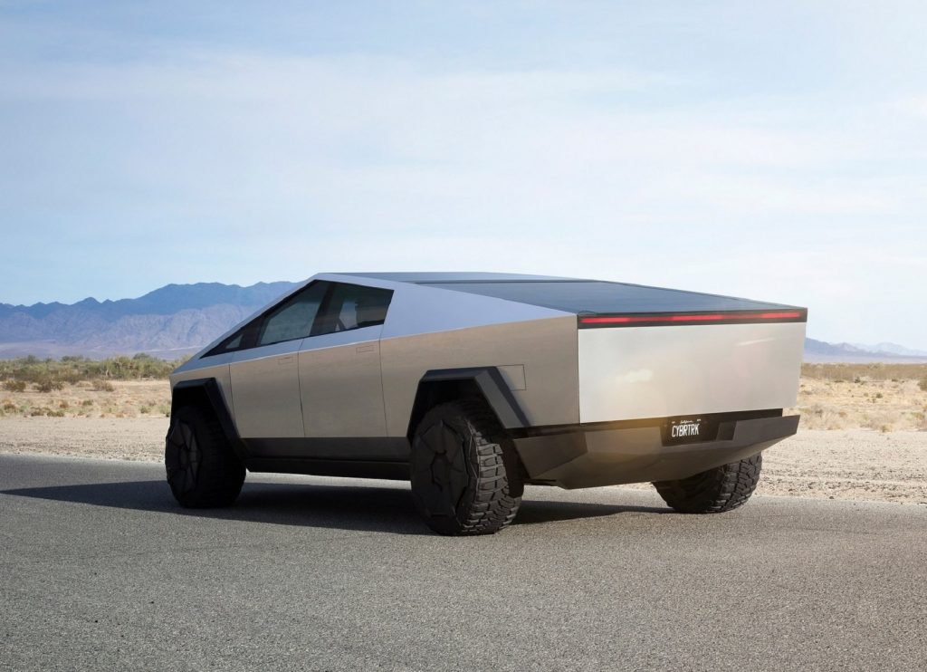 The rear 3/4 view of the stainless-steel Tesla Cybertruck concept on a desert track