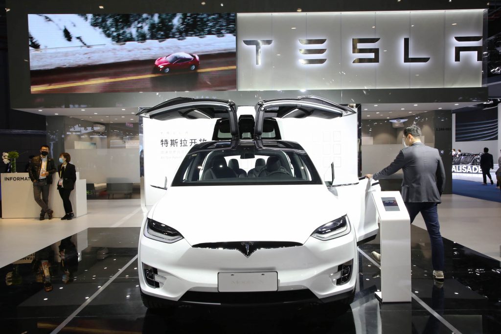 A visitor experiences a white Tesla Model X during the 3rd China International Import Expo (CIIE) at the National Exhibition and Convention Center