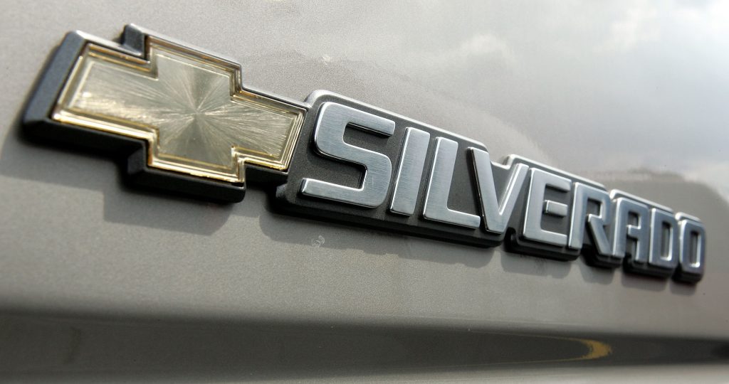 A Silverado badge on the back of a silver truck