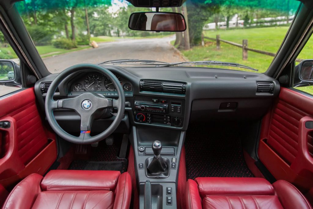 The modified red-leather front seats and black dashboard of a 1991 BMW 325iX