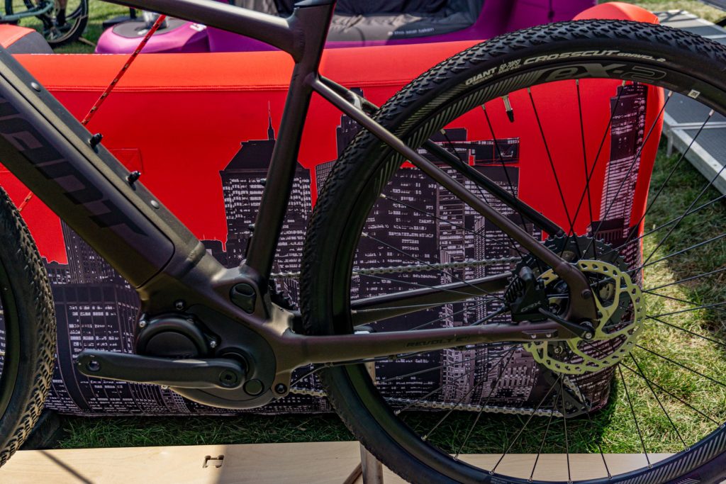 A close-up view of a dark-purple 2021 Giant Revolt E+ Pro's motor and rear derailleur