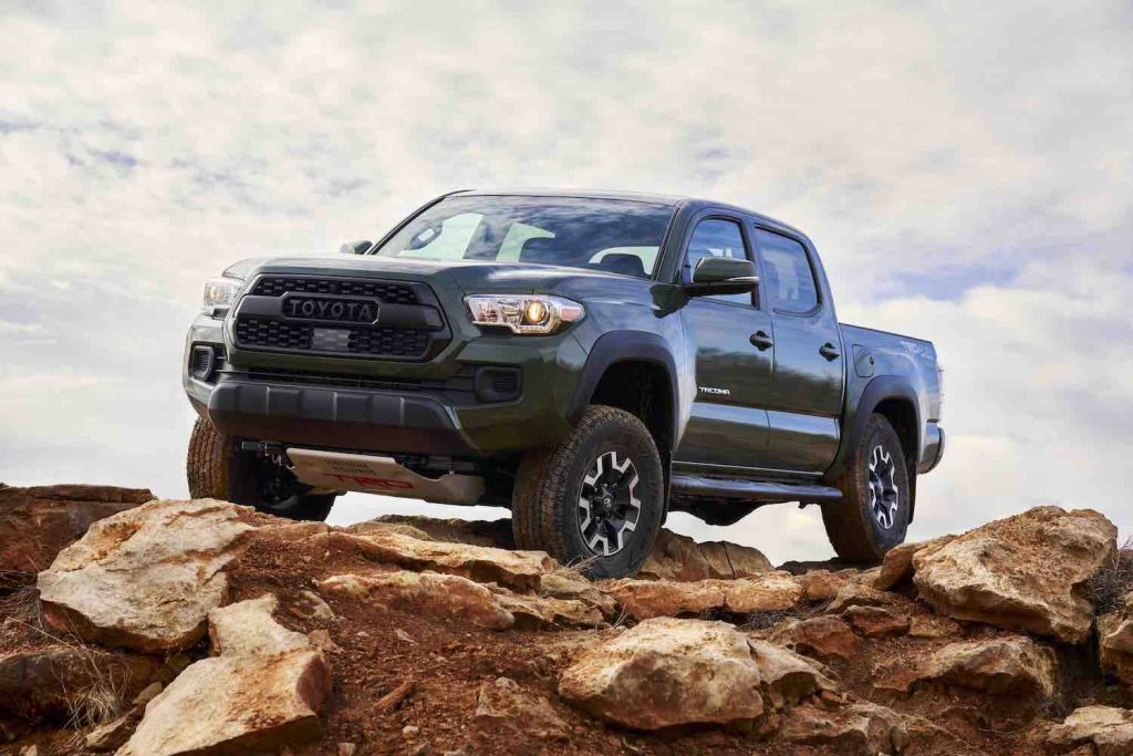 A green 2021 Toyota Tacoma rock climbing, the Tacoma is one of five Midsize Trucks with the Best Gas Mileage in 2021, According to TrueCar