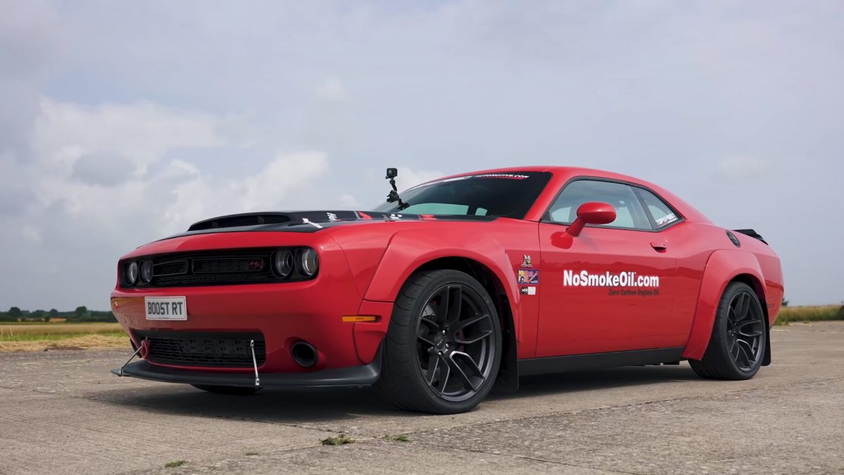 Red supercharged Dodge Challenger SRT with Scat Pack widebody preparing for a drag race.