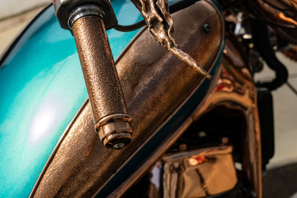 The close-up view of the fuel tank and right handlebar on Mike Prete's turquoise-and-copper custom 1998 Suzuki Intruder